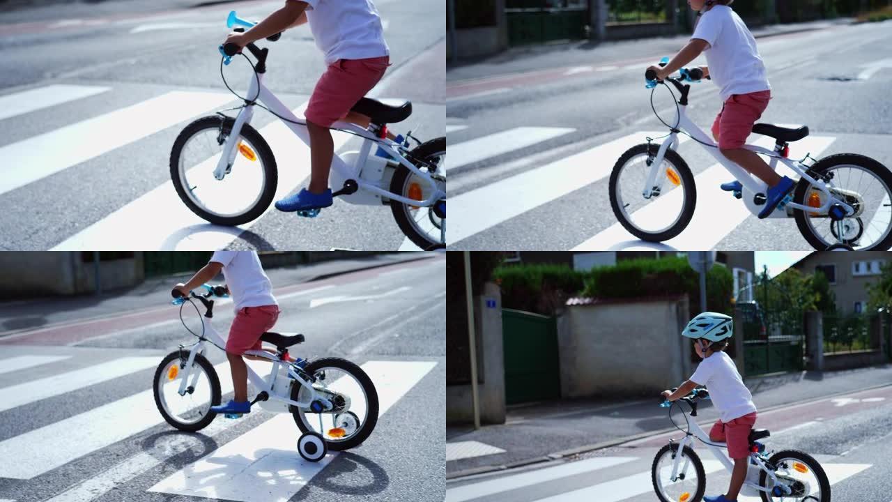 带自行车和头盔的儿童过街。在城市街道人行横道上骑带轮子的运动儿童自行车
