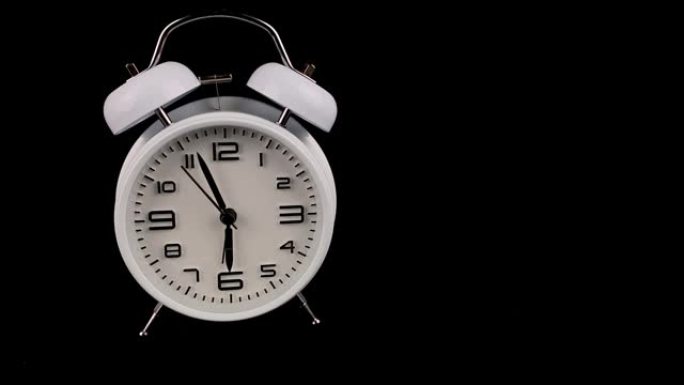老式的白色闹钟站在黑色背景上，早上6点6点响起。
