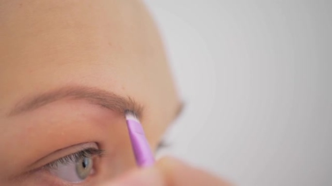 一个女人用化妆使眉毛变黑的特写镜头