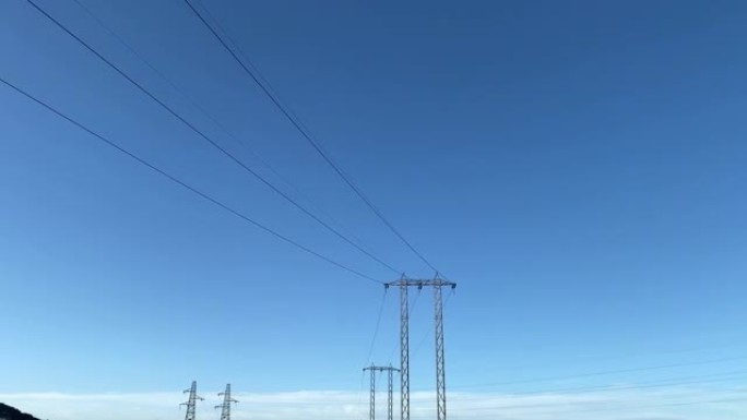 蓝天背景下的高压输电钢塔，城市电力塔和电线电缆为人们提供能源或电力，电力的传输和分配不间断