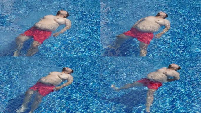 超重的亚洲男子漫不经心地漂浮在游泳池中间