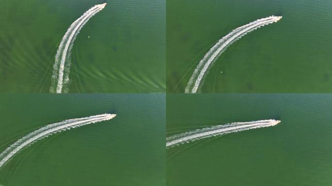 白色快艇在波浪表面快速游动的鸟瞰图。机动船在海洋上高速行驶