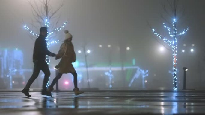 浪漫的情侣沿着雾蒙蒙的街道散步。慢动作