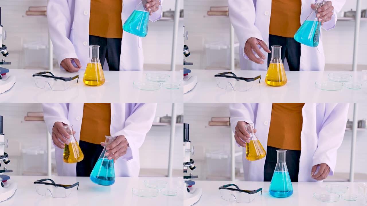 4K，科学老师的双手特写，拿着烧瓶，双手颤抖，将颜料和水混合在一起，在科学室进行实验，两个瓶子用来混