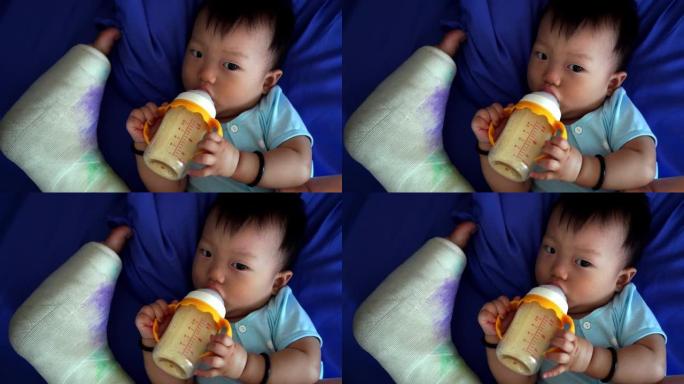 男婴在母亲断腿旁边喝牛奶