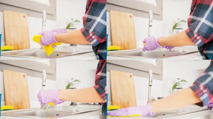 手在乳胶手套清洗厨房水槽的特写镜头