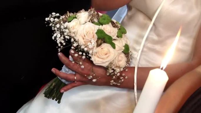新娘手持玫瑰花束参加其参加的宗教仪式