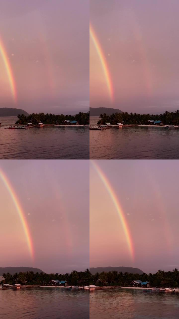 日落时天堂热带岛屿上的彩虹空中拍摄的垂直视频
