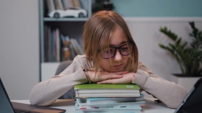 坐在桌子旁的青春期女孩的特写镜头，在家里背景书柜上的一大堆书中，想着解决学校的课程考试。