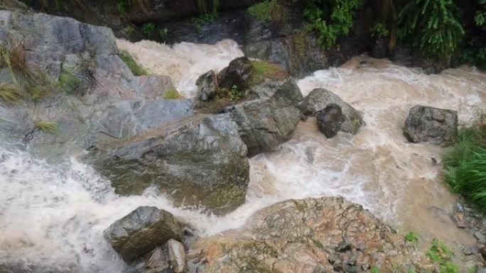 台风下雨时，水在尼泊尔山丘上的瀑布岩石上肆虐。
