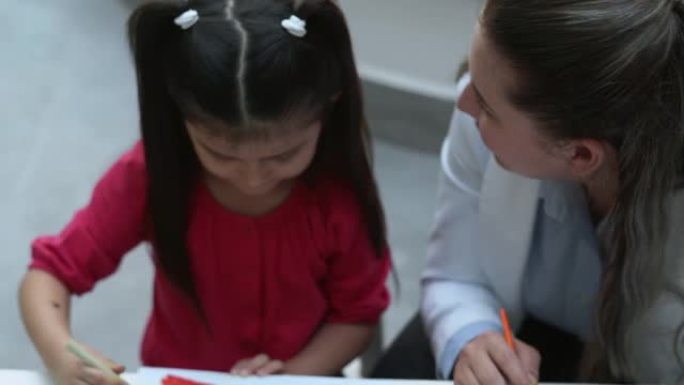 女心理学家和小女孩在治疗期间绘画