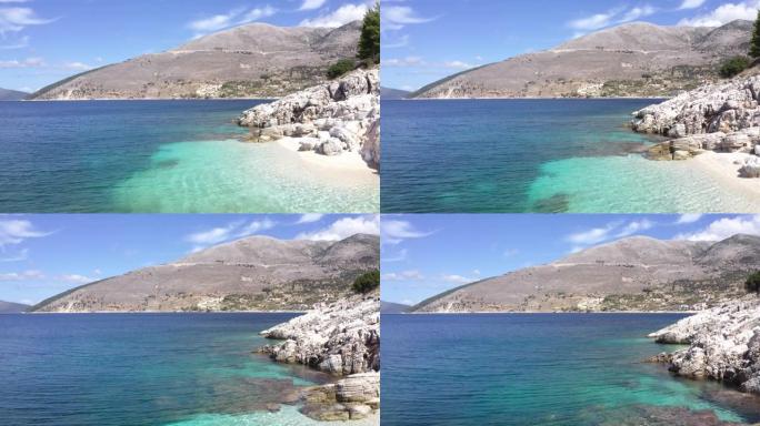 缓慢飞行的无人机在Cephalonia希腊岛岩石海岸白色卵石舒适的海滩。离子海浪景观4k镜头。大自然