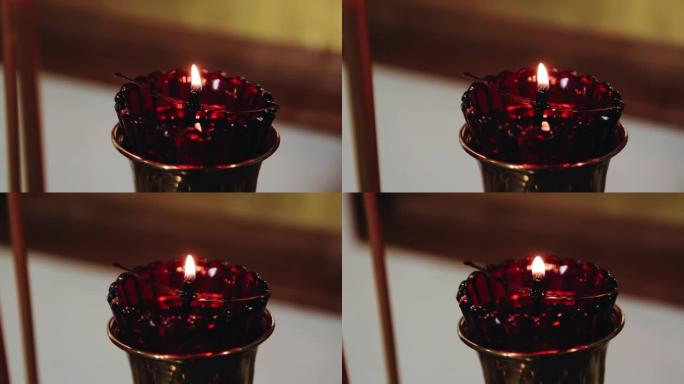 在寺庙的祭坛上的小杯子里燃烧的蜡烛的特写镜头