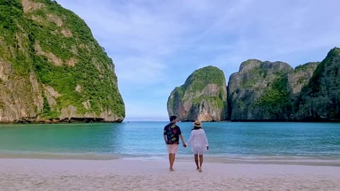 清晨，男女夫妇在海滩上散步，泰国马雅海滩
