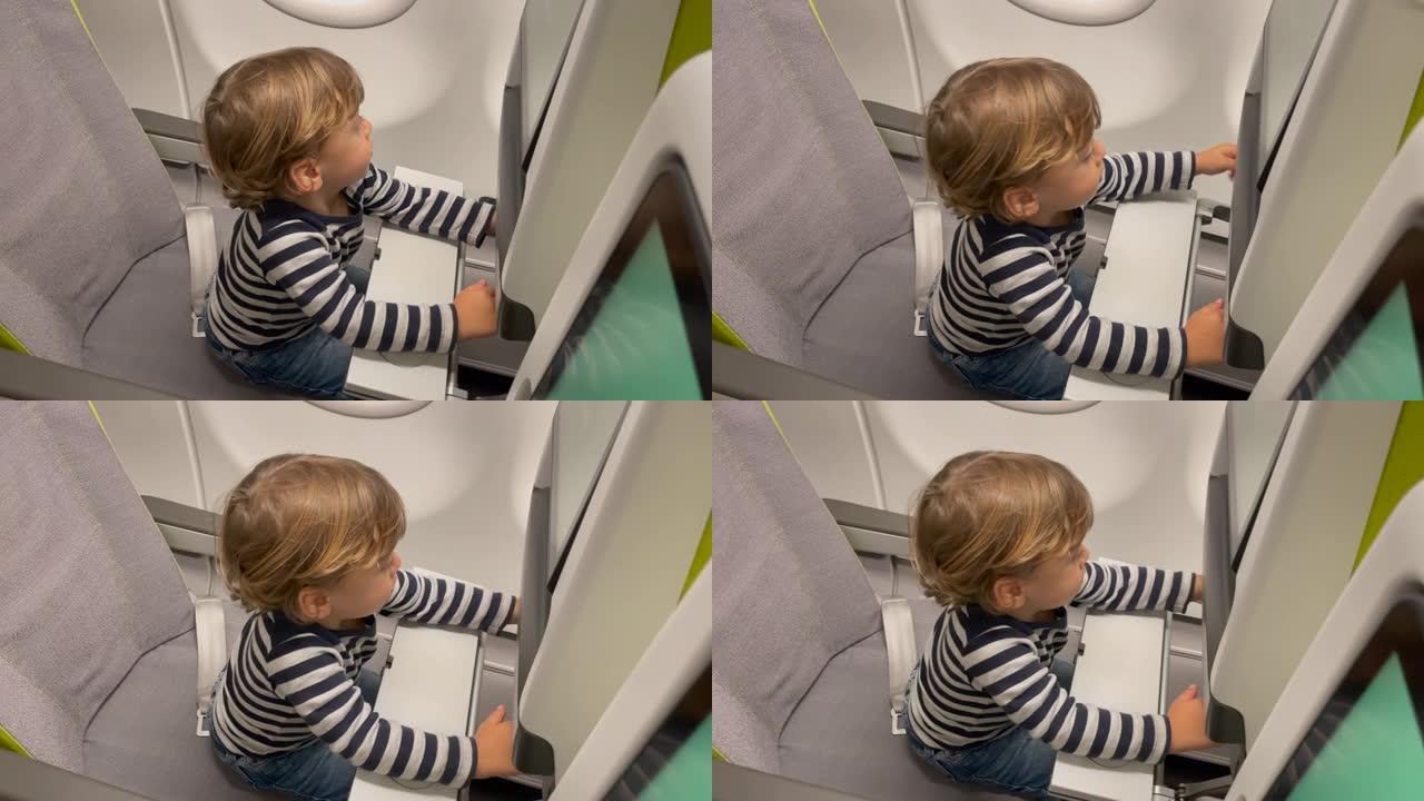 一个小男孩坐在飞机椅子上。乘飞机旅行的小乘客。机舱内有行为的孩子。生活方式飞行概念
