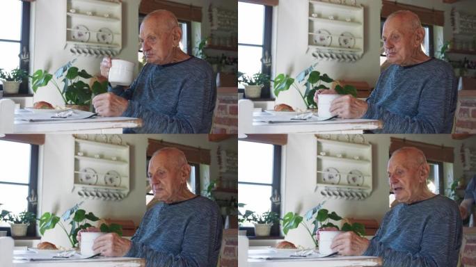 老人坐在家里，喝牛奶，在室内吃早餐。