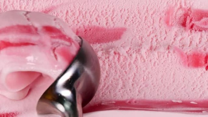 慢动作草莓冰淇淋用勺子舀。