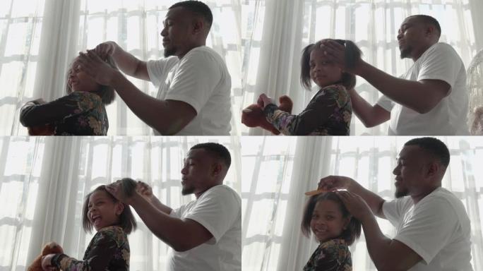 非裔美国人家庭爸爸使用发刷梳理女儿
