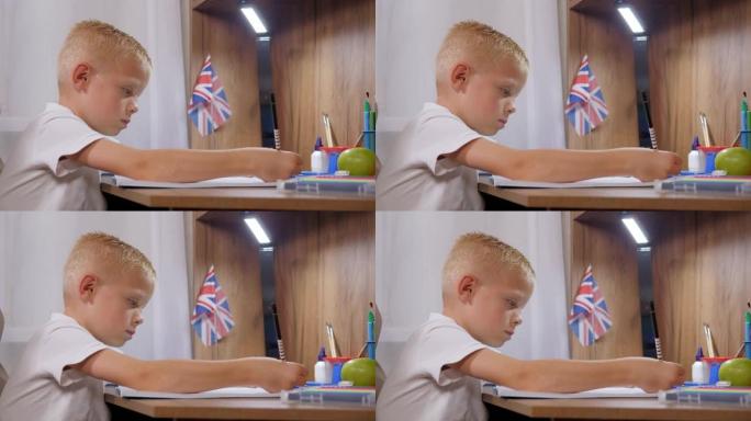 一个小学生在笔记本上写字的特写镜头坐在家里的桌子上