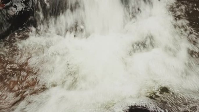 山间溪流中的水掉落在岩石和巨石上的录像