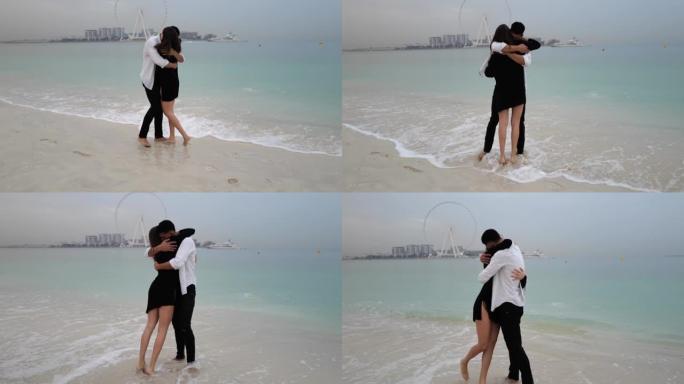 年轻的跨种族夫妇在海滩上拥抱