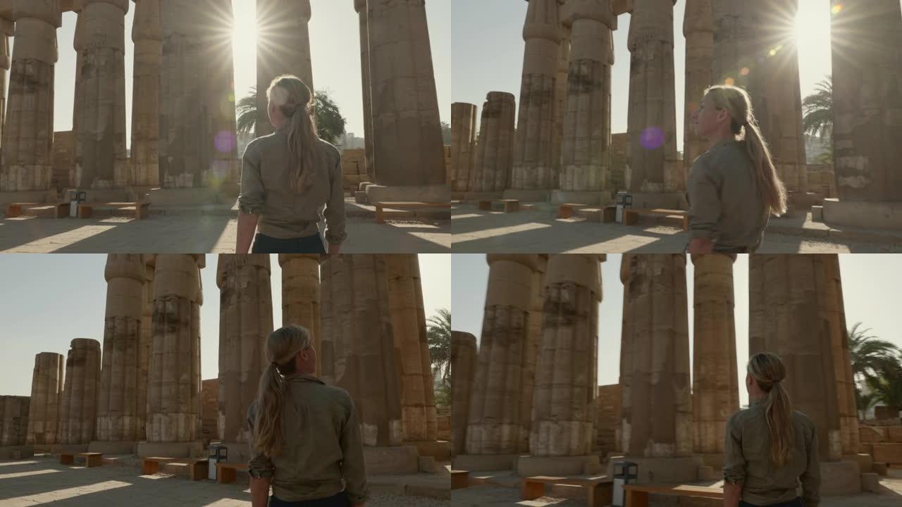 年轻的女性旅行者在埃及卢克索的古老卡纳克神庙中徘徊。女性旅行者观光古埃及神庙