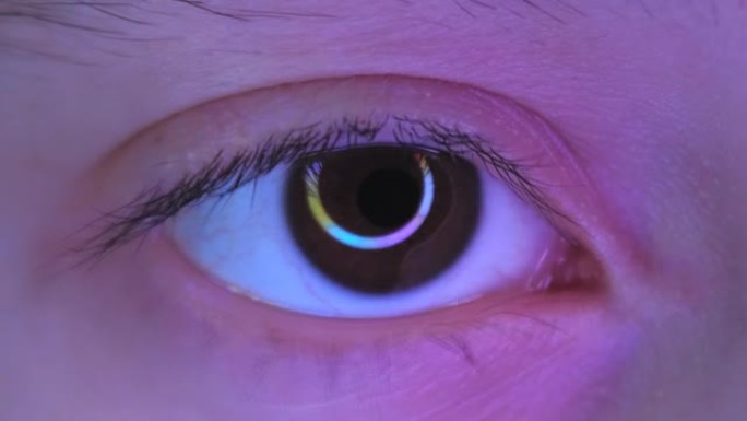 青少年眼睛的特写，圆形RGB灯在眼睛中的反射。