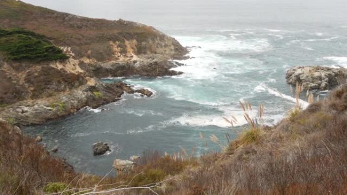 岩石崎岖的海洋，有雾的天气。海浪冲击海滩。加利福尼亚，大苏尔。