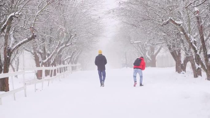 两个人一起走在冬天的路上。在雪地里嬉戏