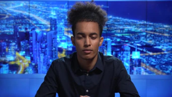 4k视频: 非洲男性新闻播音员在迪拜电视演播室阅读突发新闻
