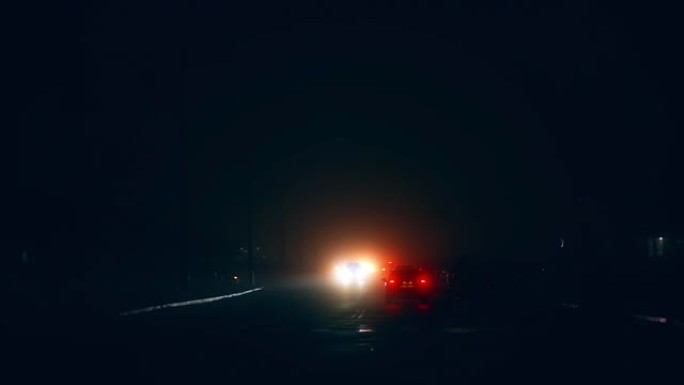 夜间停电的黑城。汽车，自行车和手电的行人在黑暗的道路上移动。