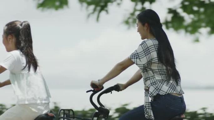 亚洲母女夏季在海滨长廊骑自行车