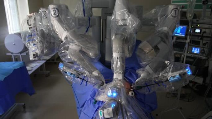 操作病人的医疗机器人。机械手活动手臂在人的腹部移动。背景下的视觉推车。
