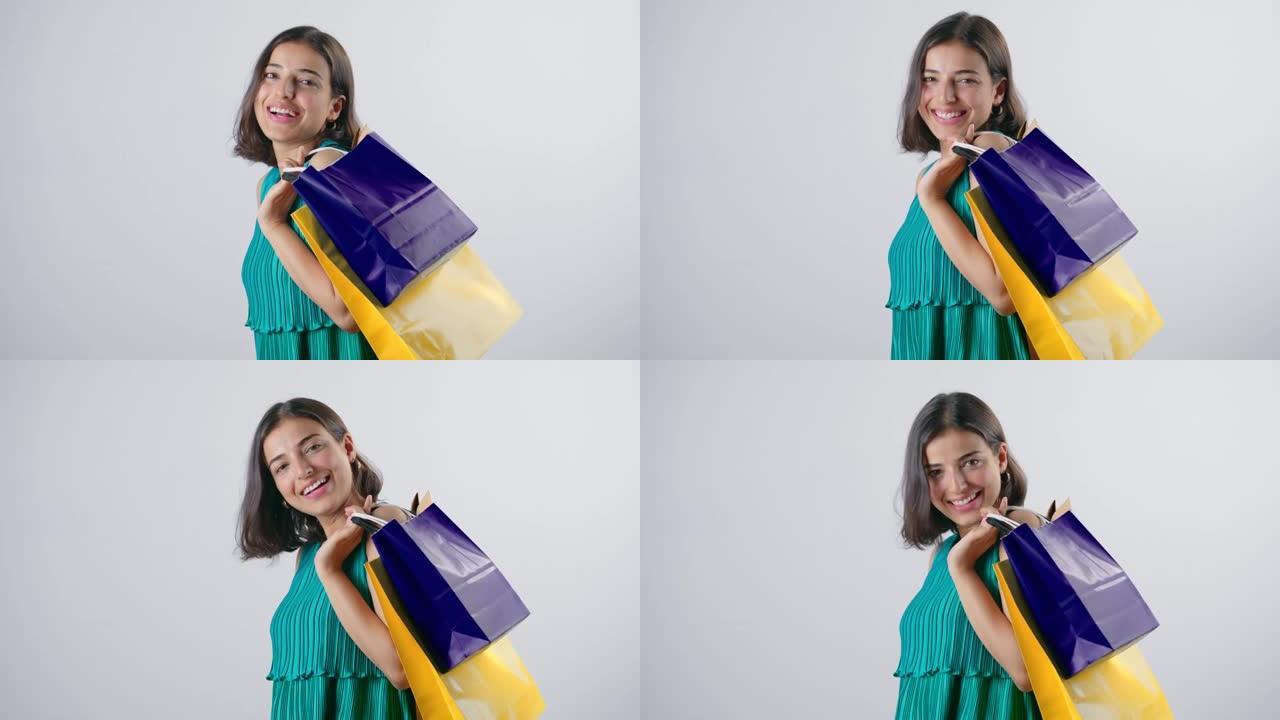 年轻开朗的印度妇女肩上扛着五颜六色的购物袋