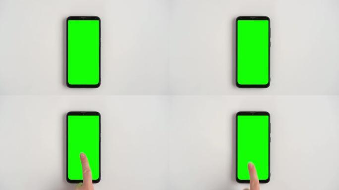 手势。女性用chromakey绿屏在手机上触摸，点击，点击和滑动。女孩放大缩小。特写4k素材包。使用