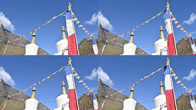 在尼泊尔昆布地区最大的夏尔巴人村庄Khumjung村的白色佛塔上，迎风飘扬的经幡。