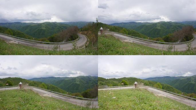 云层在茂密的森林的高山上飞驰而过，在延伸的折弯中下降的道路上99