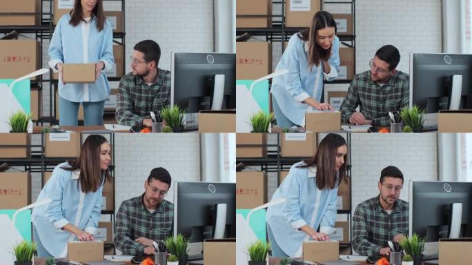一个年轻人使用计算机，一个女人确认盒子上的联系方式。一男一女在仓库工作。