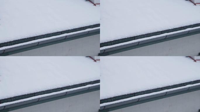 冬天用冰柱覆盖的积雪屋顶排水沟