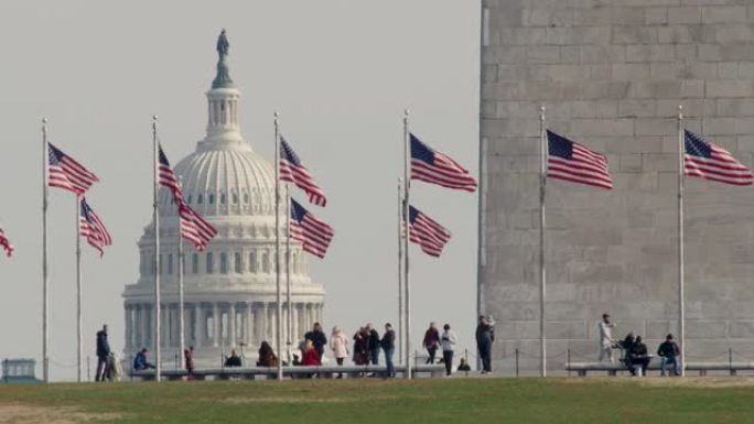 旗帜在华盛顿纪念碑底部与美国国会大厦圆顶缓缓飘扬
