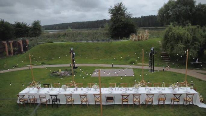 节日装饰餐桌的俯视图，上面放着一束柔和的鲜花和绿色的花瓶。婚礼用新鲜花束制成的花卉成分，模糊，慢动作