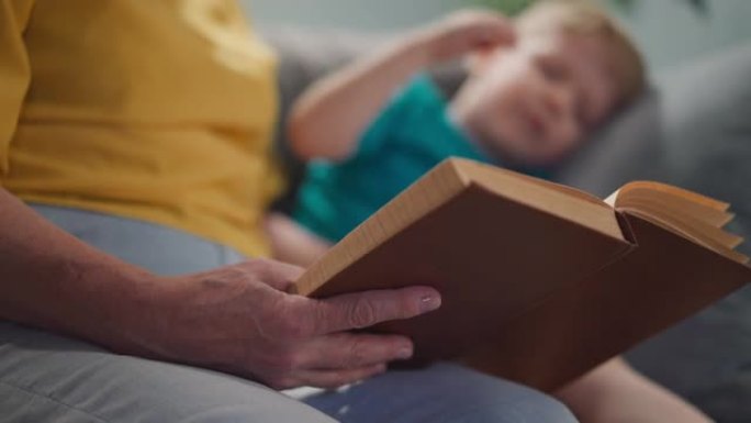 沙发上的小男孩给女人读的老式童话书