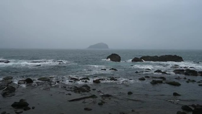 台湾基隆市八斗子鱼港海岸线上的岩石上溅起了阴雨天。