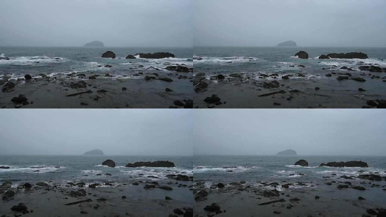 台湾基隆市八斗子鱼港海岸线上的岩石上溅起了阴雨天。