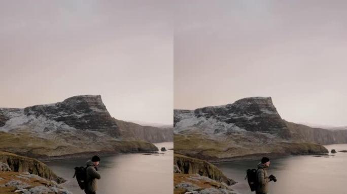 摄影师站在苏格兰高地的悬崖边缘