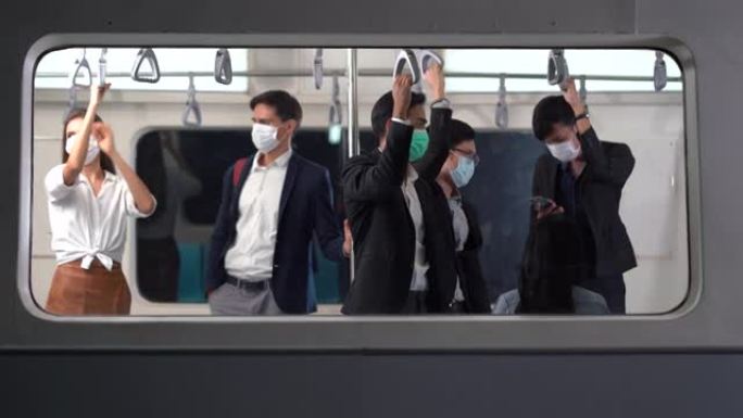 一群戴着外科口罩的多元化人站在一起挤在地铁里。冠状病毒或新型冠状病毒肺炎大流行的公共交通新常态
