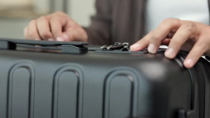 关闭男性手指试图通过输入安全代码解锁行李。男士打开行李箱收纳行李。