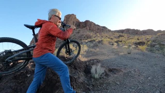 成熟的雄性山地自行车手沿着沙漠脊顶上升