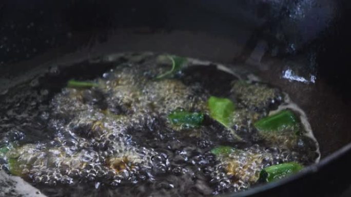 在沸腾的锅中加油厨师加入辣椒酱进行炒菜。