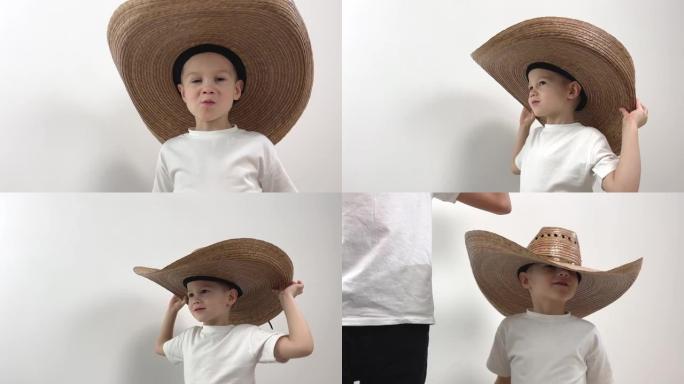 小男孩5牛仔帽大帽子适合眼睛他伸直t恤是孤立的白色背景他微笑旋转使他的眼睛适合成人和儿童的文字衣服头